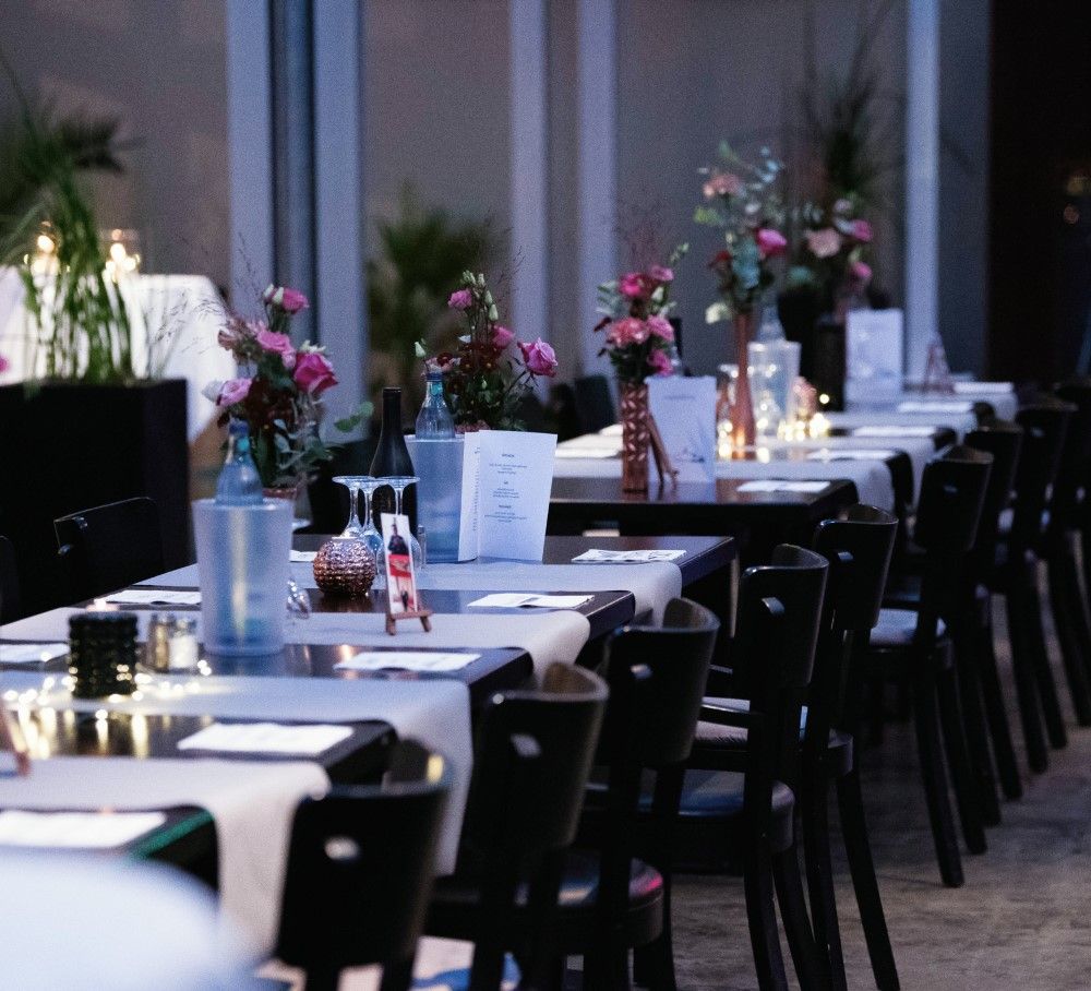 Ein schön gedeckter Restauranttisch mit stilvoller Tischdekoration, Geschirr, Besteck und Gläsern